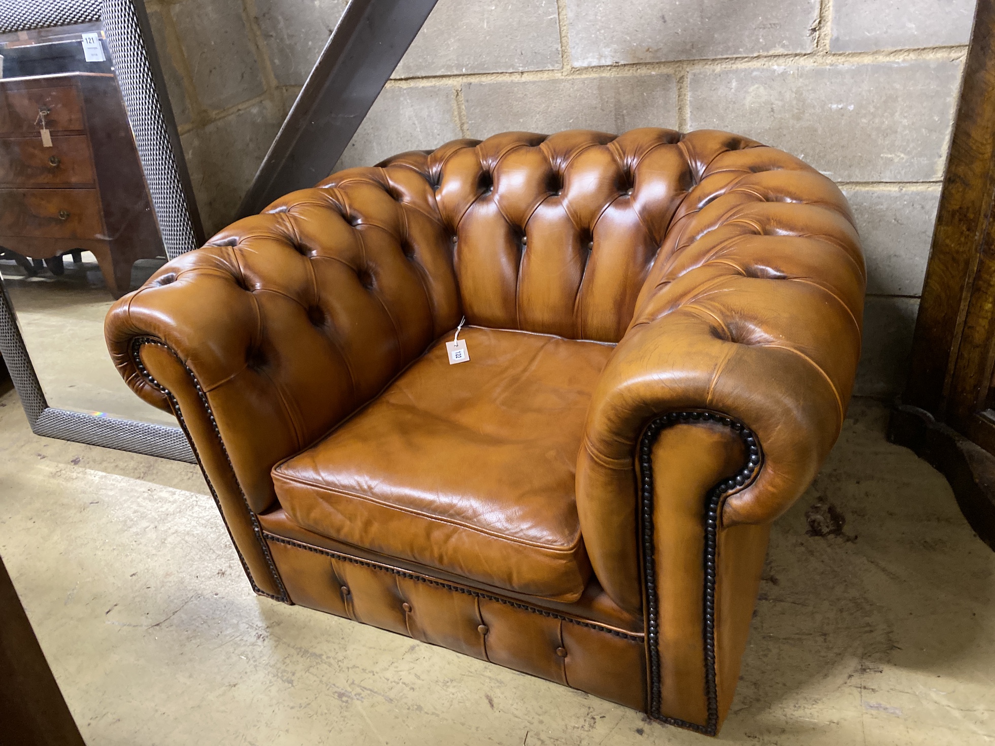 A Victorian style tan leather Chesterfield type armchair, width 102cm, depth 84cm, height 60cm